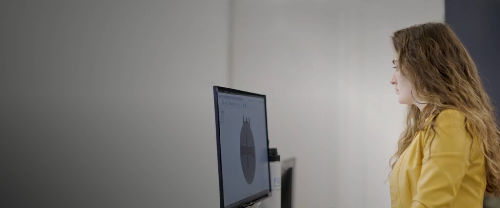 Woman in yellow looking at computer screen