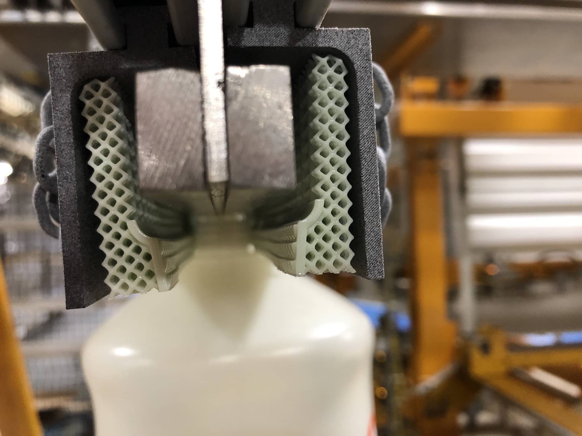 Carbon lattice gripping bottle on factory floor